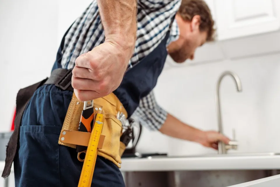 Plumber with wrench from tool belt